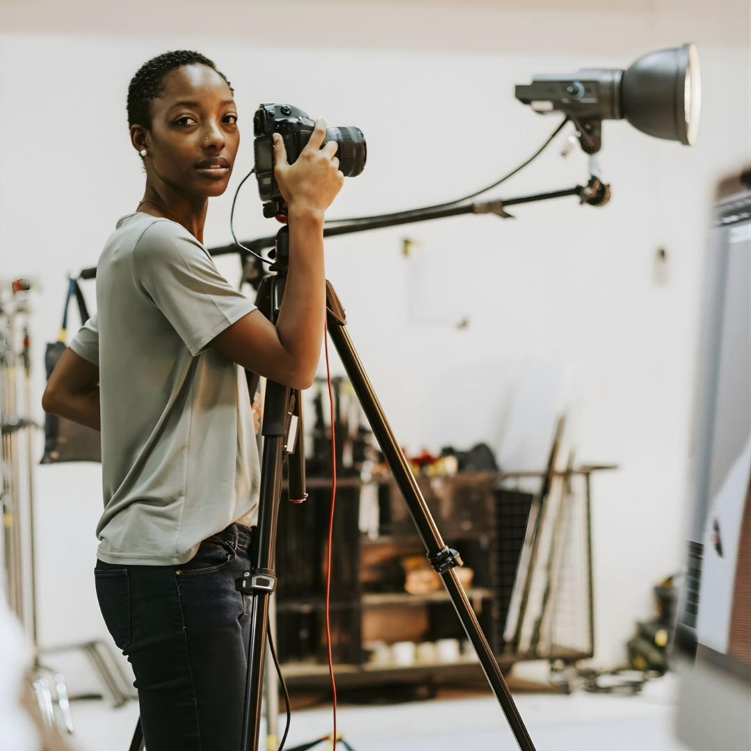 Student using a professional camera and lighting setup during EVT media production training program