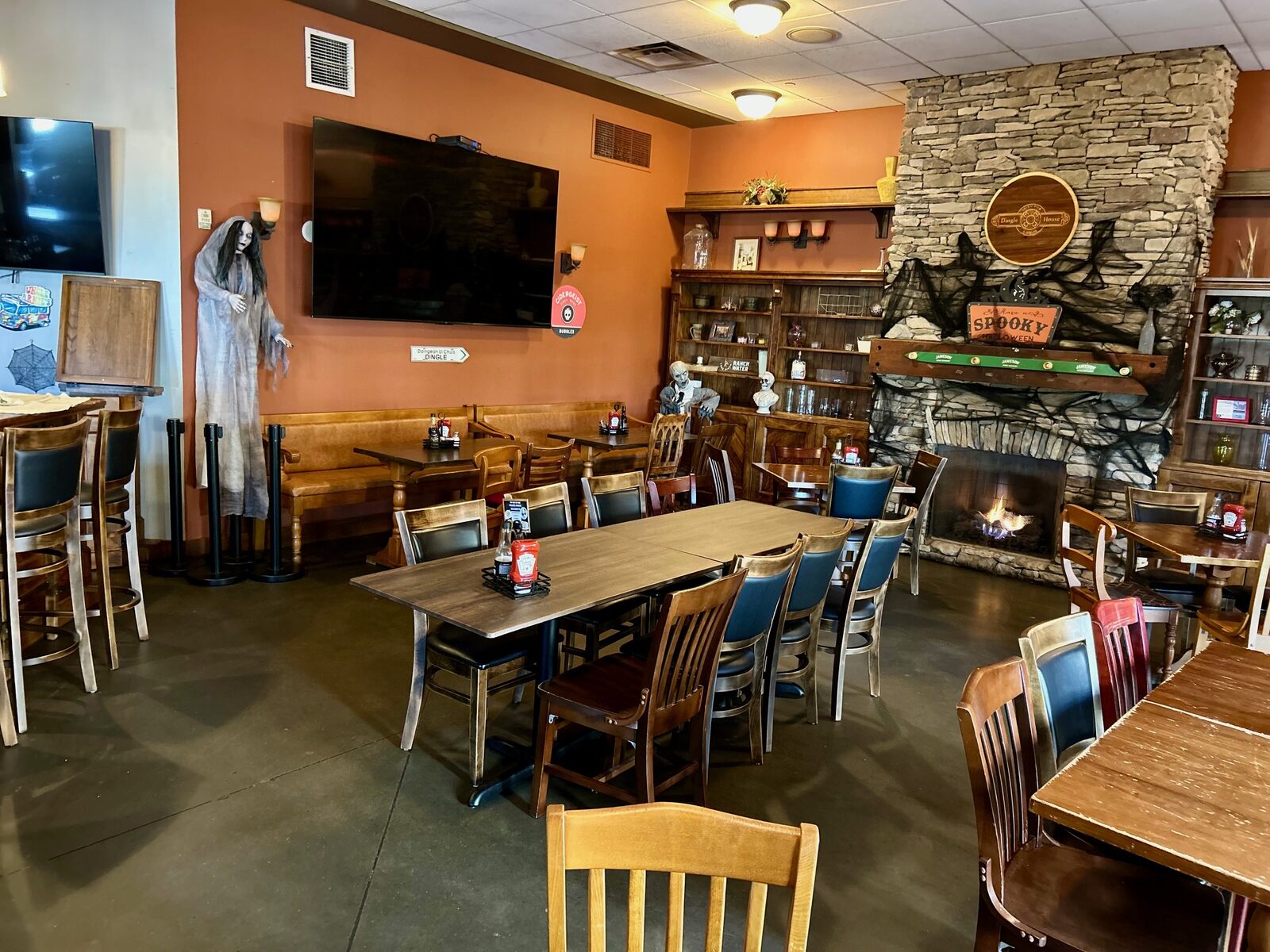 Dining room with tables in front of the stone fireplace
