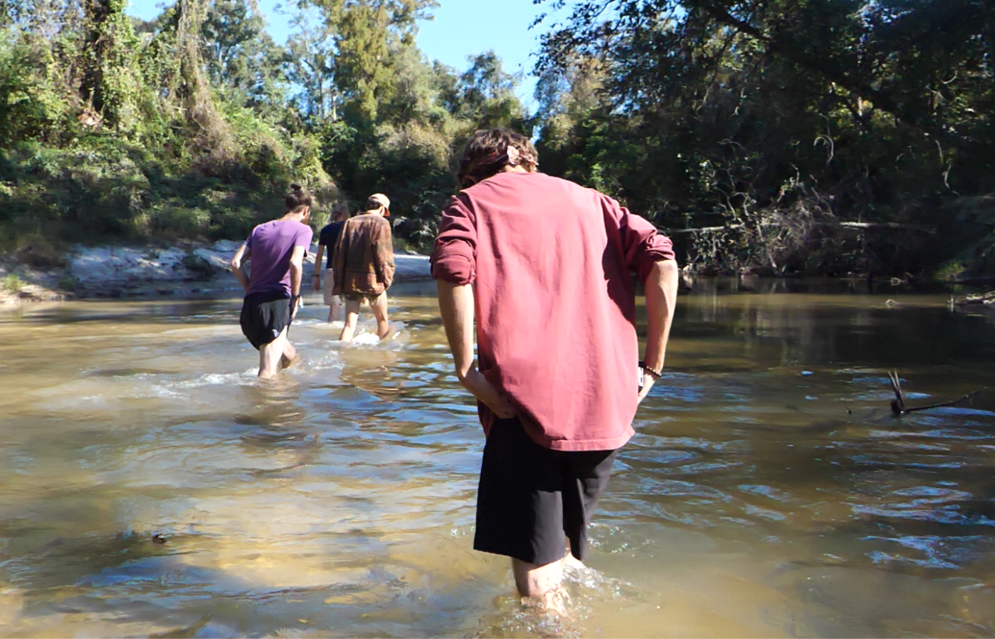 Men walking together through a river during The Men's Portal retreat
