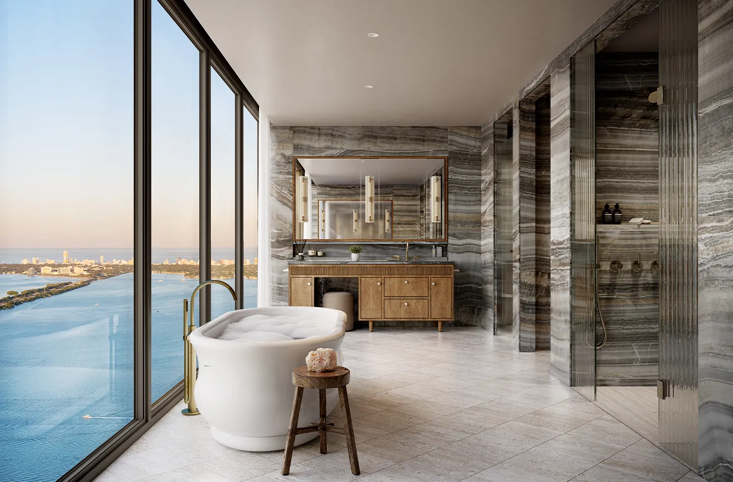 A primary bathroom with a freestanding tub, stone walls and a view of the water