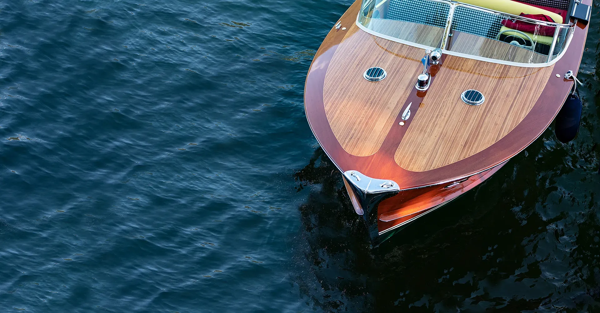 Aerial view of a wooden speedboat crossing deep blue water