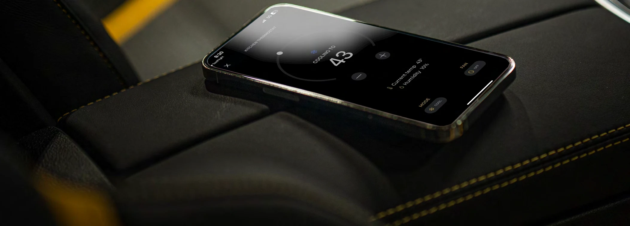 Smartphone running the CollectionSuites App on a leather car seat