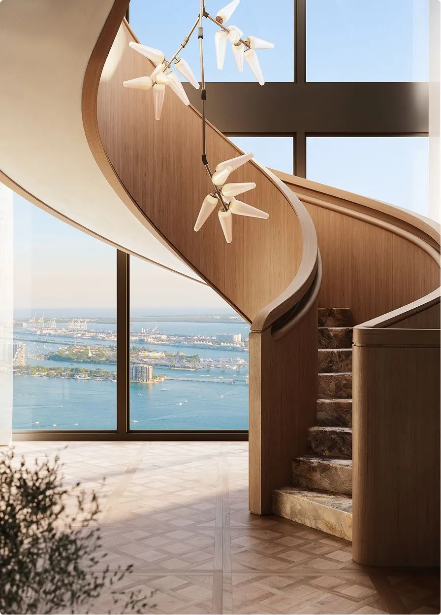 A spiral wooden staircase rising beside a window with a view of the bay