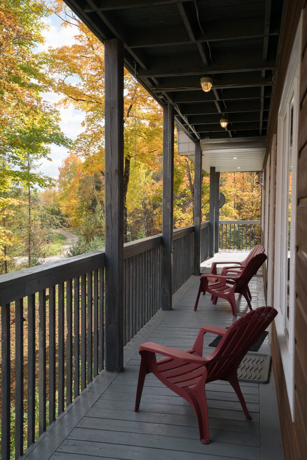 Wrap-around porch with red Adirondack chairs