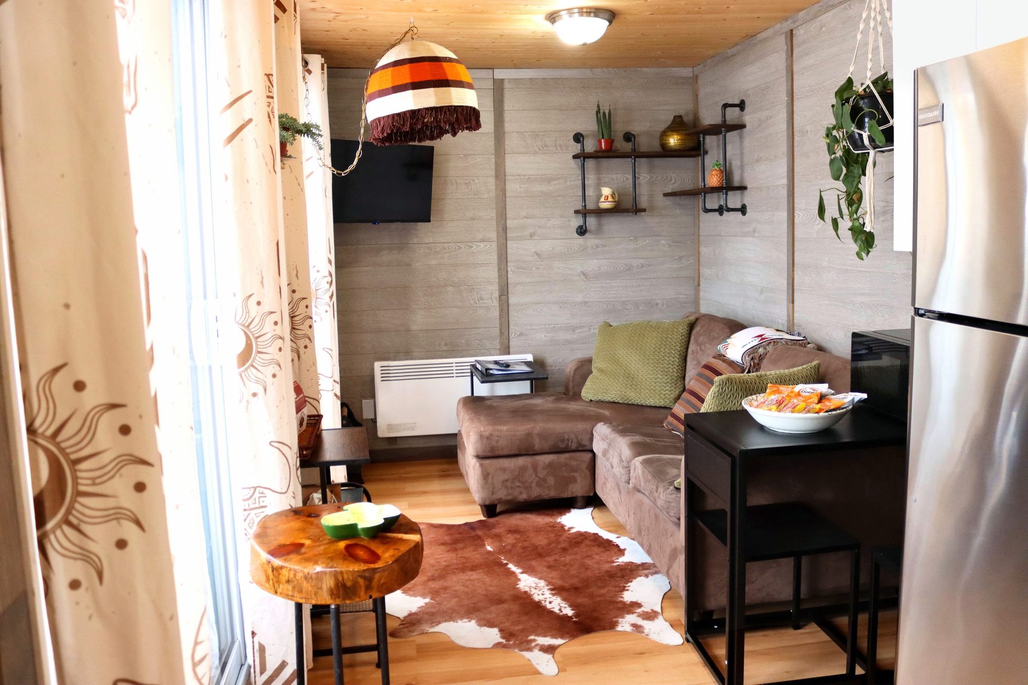 Salon avec tapis en peau de vache et fenêtre sur le lac, Villa B