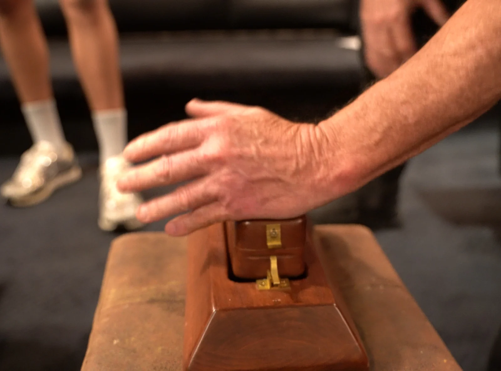 A hand over the hardwood toggle block, the brass latch set
