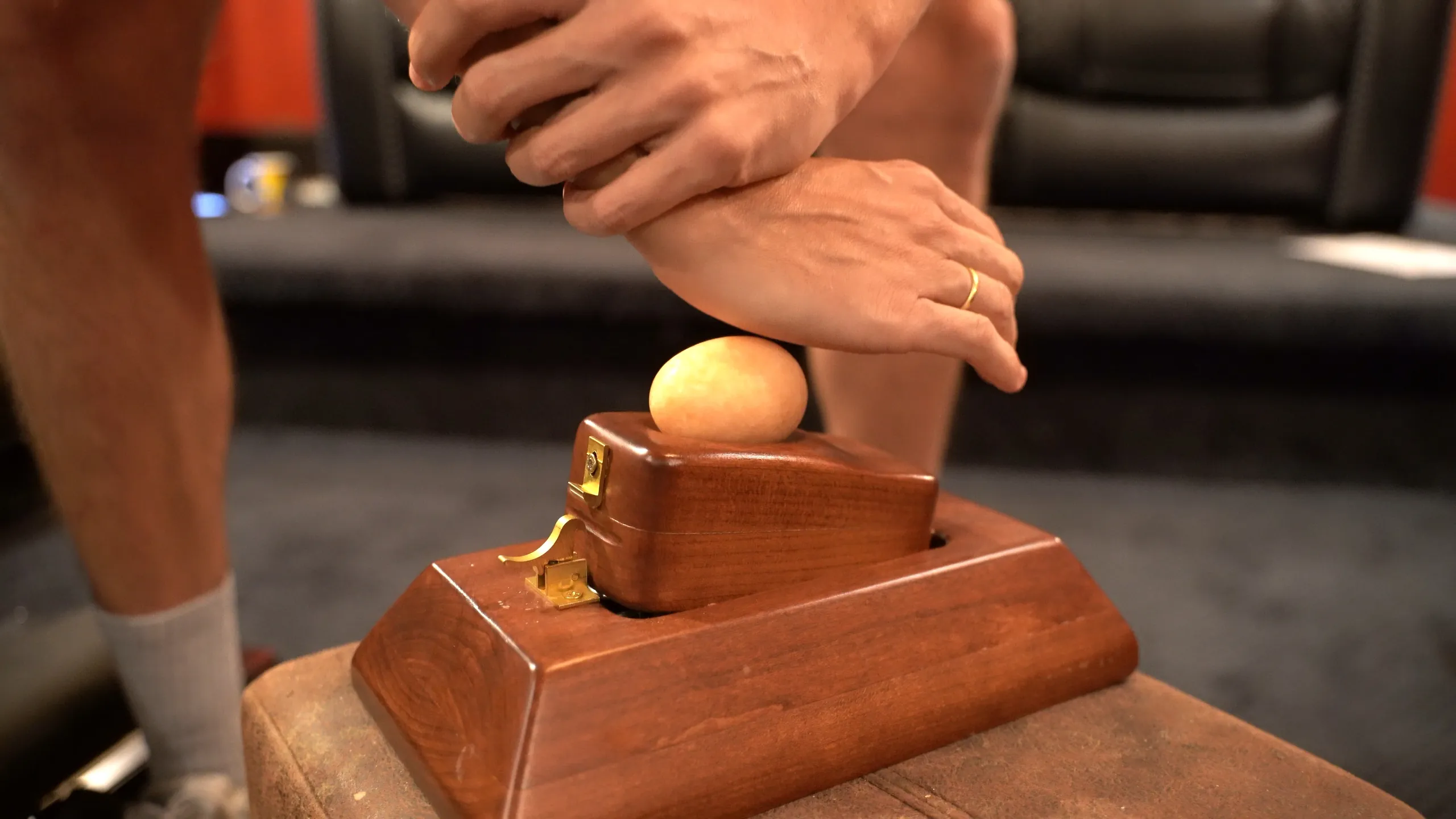 Hands stacked in the toggle position over an egg on the hardwood Kale toggle block, the egg drill at the September certification seminar