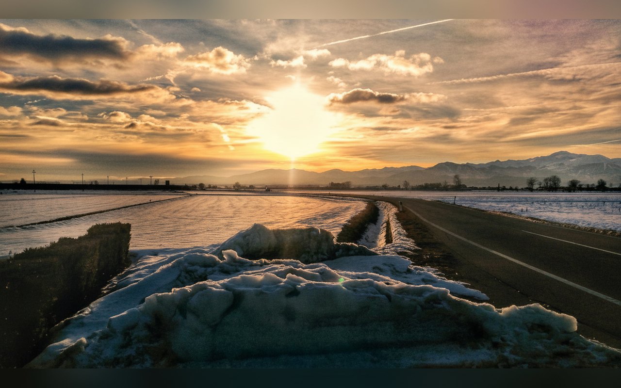Tramonto invernale sulla pianura con le Alpi sullo sfondo
