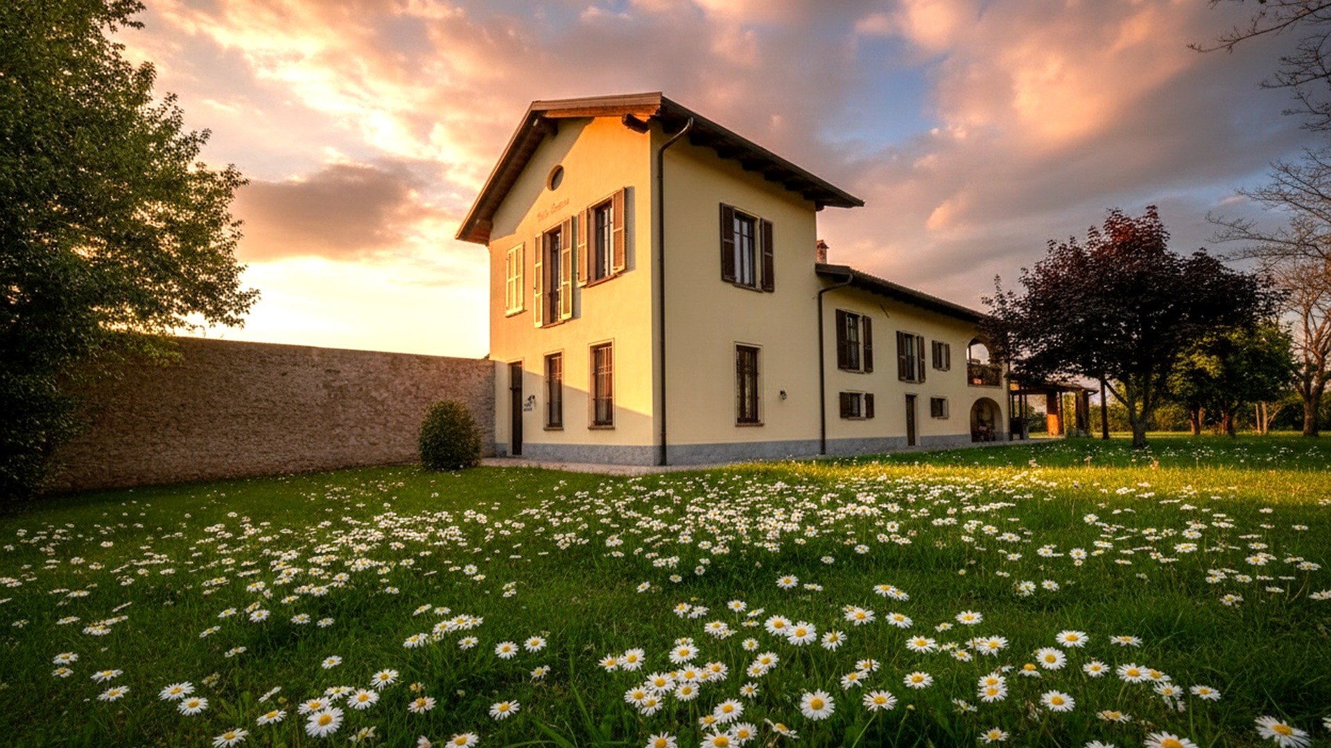 Villa Bottera al tramonto, con il prato fiorito davanti alla dimora storica