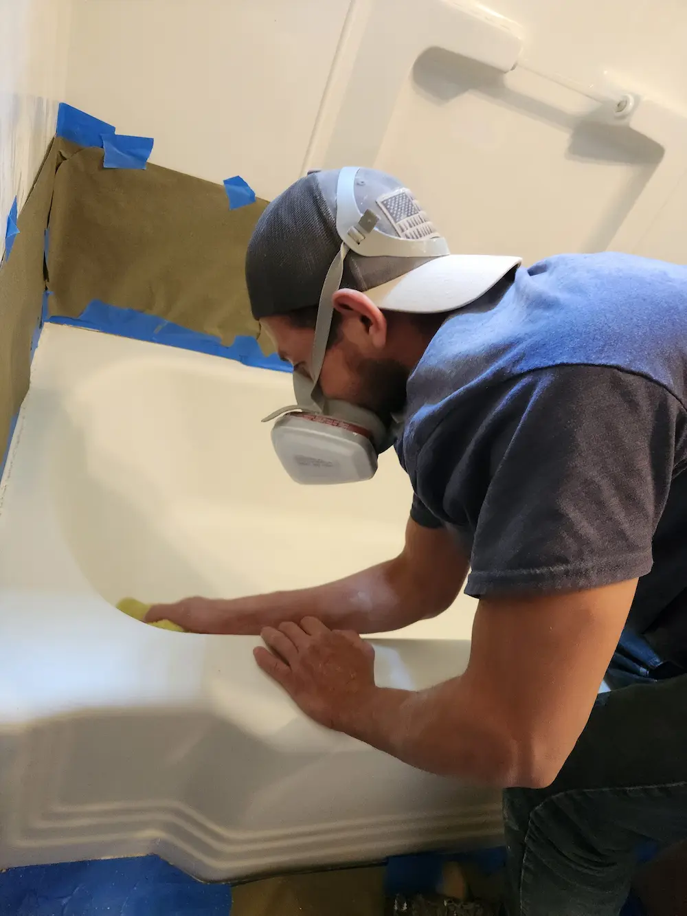 Reglaze Pro technician hand-finishing a refinished bathtub