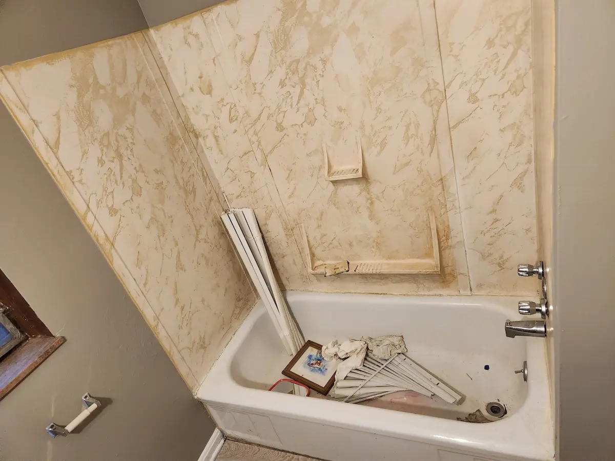 Yellowed tub surround before refinishing in an Ohio rental