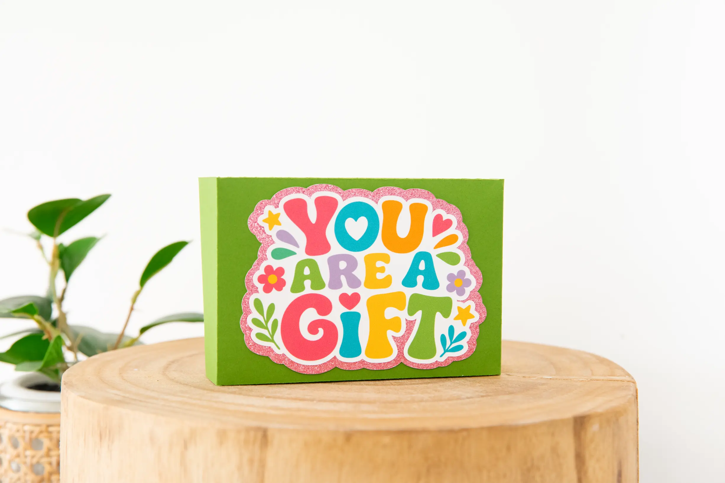 Green 3D paper gift card box topped with a colourful You Are A Gift design