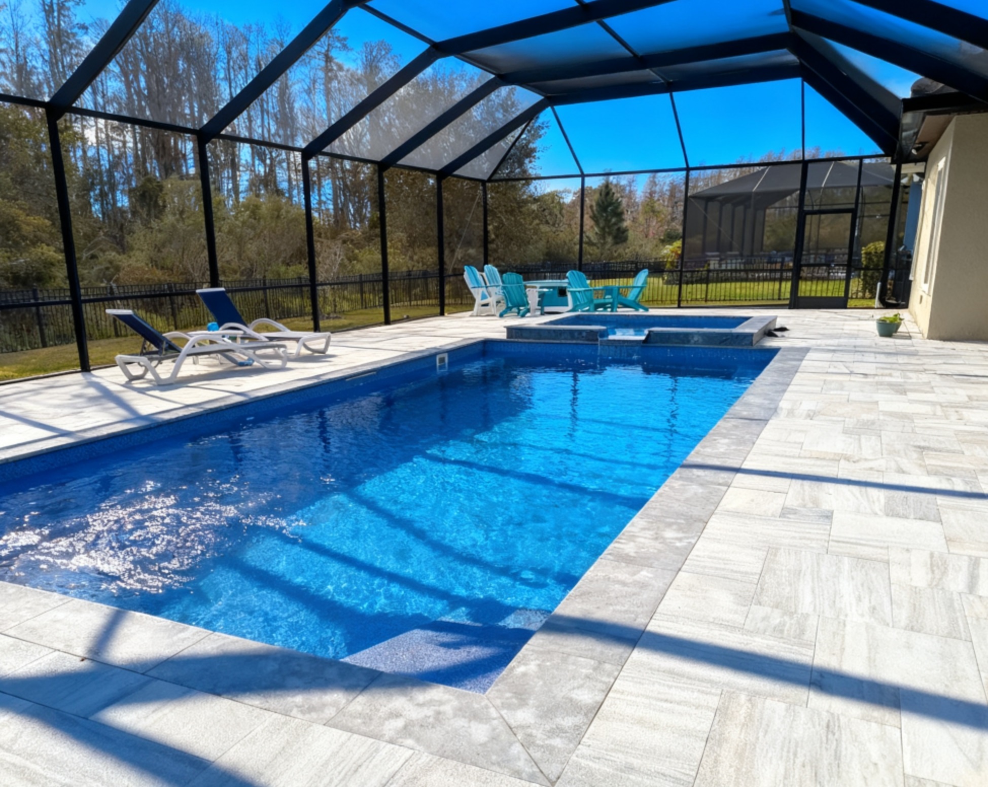 Backyard fiberglass pool with screen enclosure