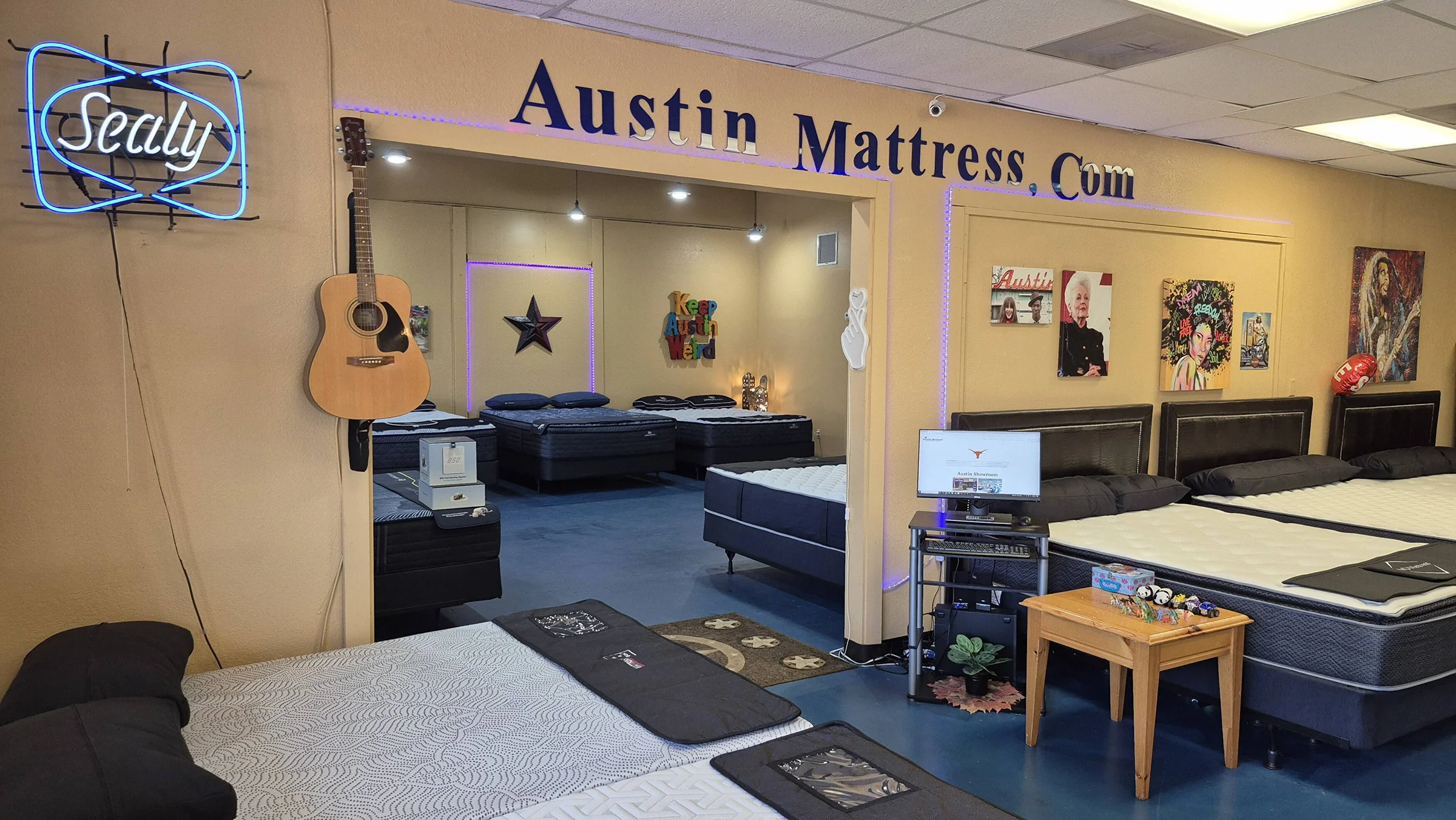 Rows of Serta, MD Mattress and Corsicana mattress sets on the floor of the Austin Discount Mattress warehouse showroom.