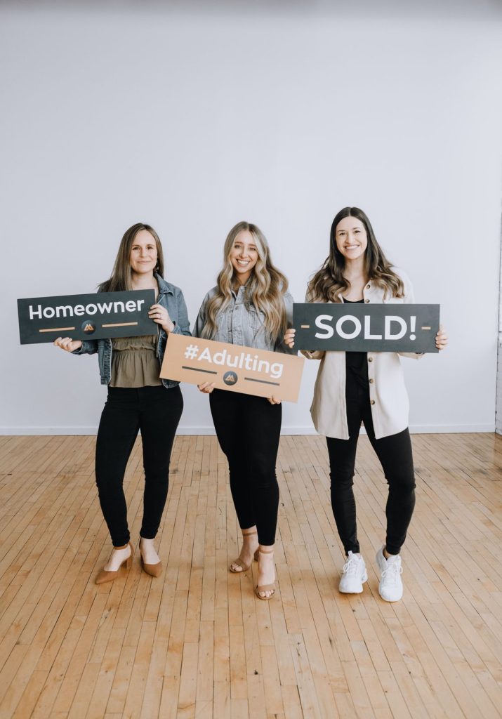 3 real estate agents holding SOLD signs