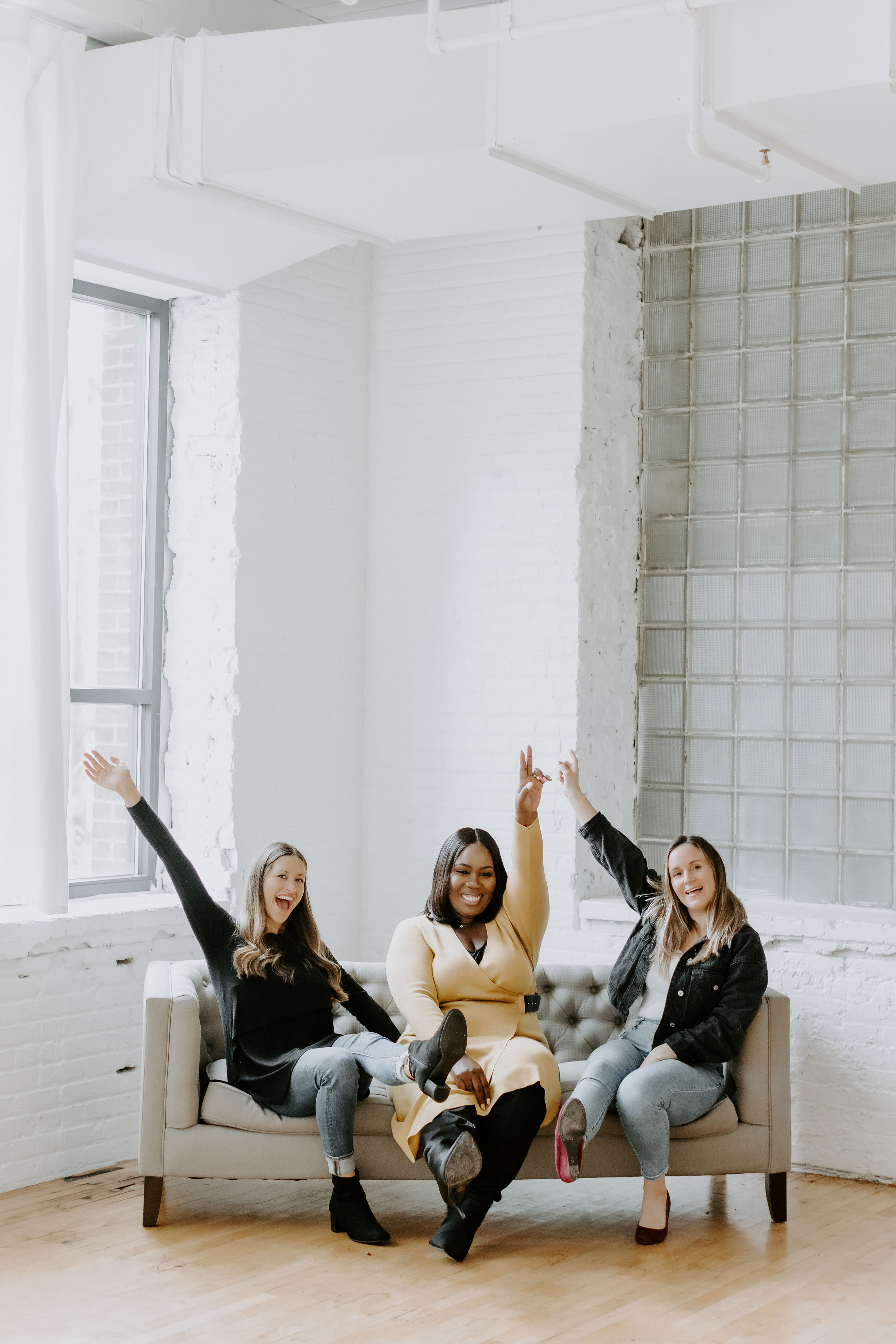 Team of people siting on a couch, talking, and smiling