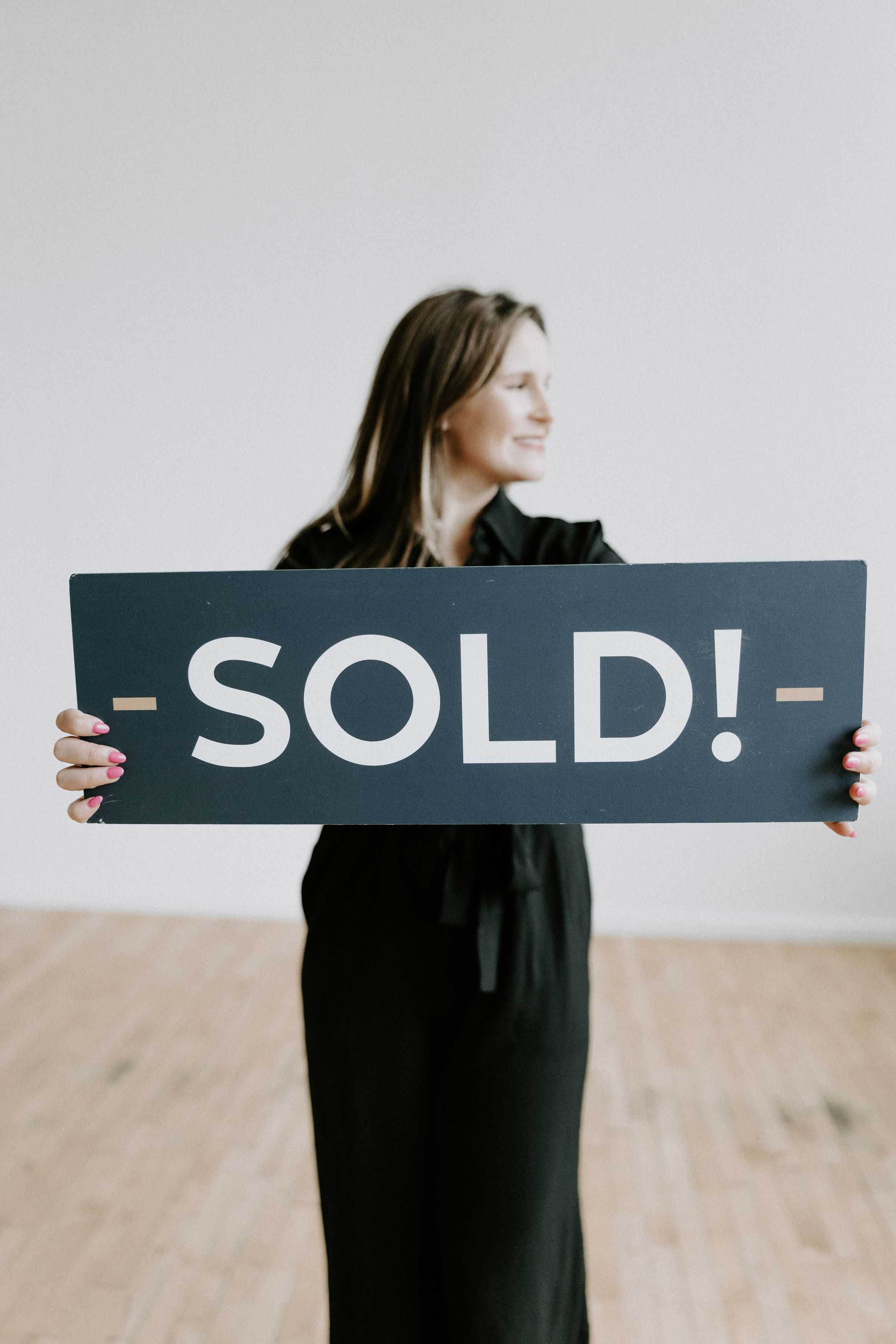 Two realtors jumping in the air holding SOLD signs