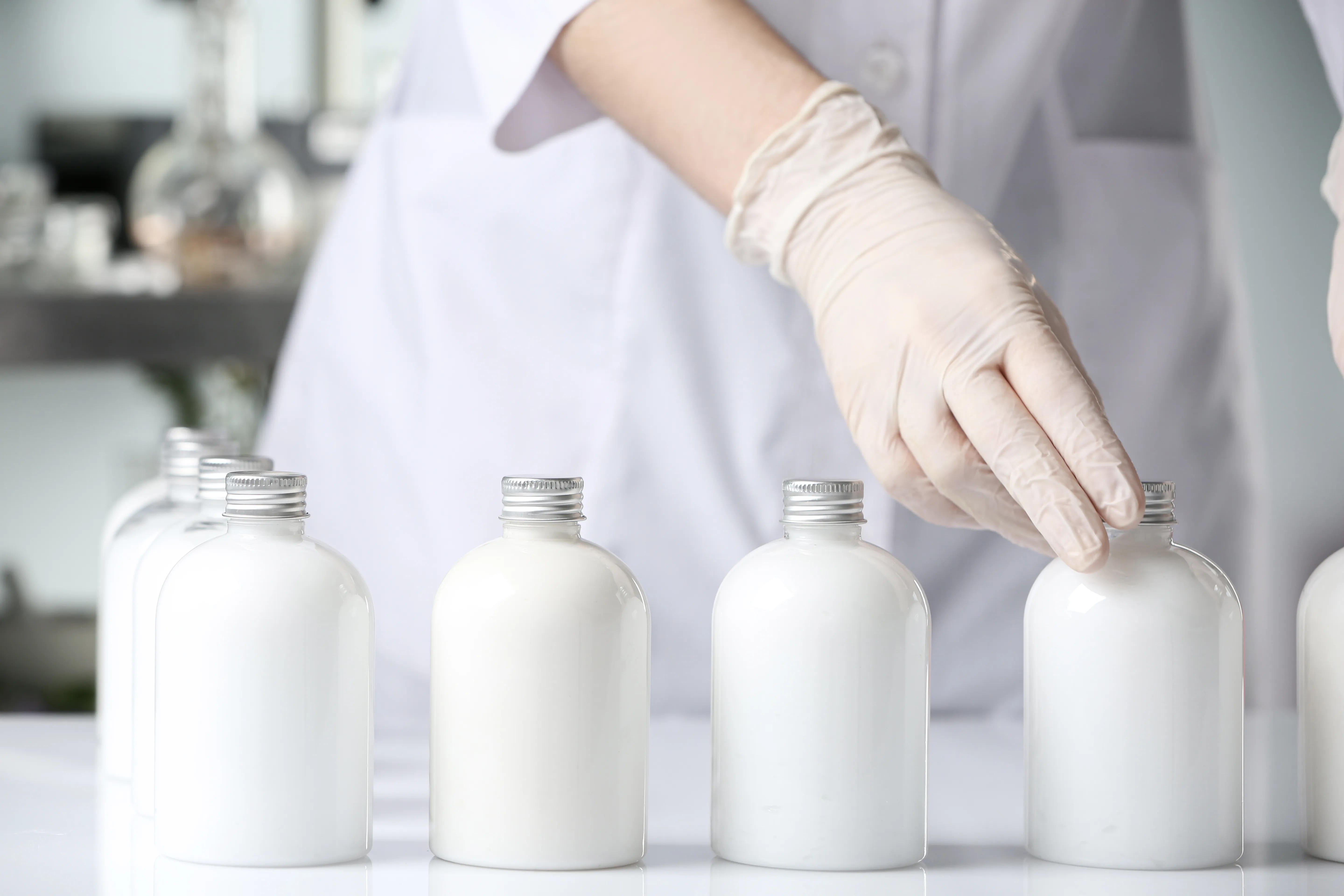 Imagen de una persona dentro de un laboratorio en medio de una linea de producción de crema corporal, con todas las medidas necesarias para adquirir la NOM 259 Imagen de una persona dentro de un laboratorio en medio de una linea de producción de crema corporal, con todas las medidas necesarias para adquirir la NOM 259