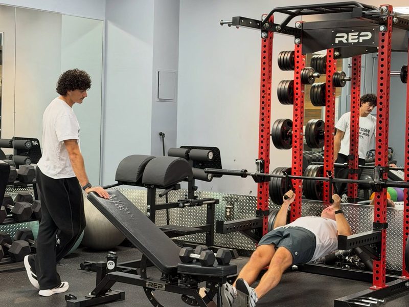 One on one personal training session at the bench with a coach cueing every rep