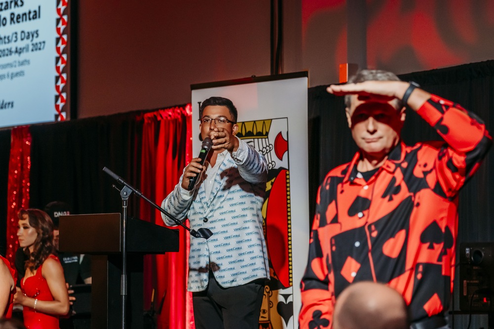 J.T. Morgan, CAI on stage calling a live auction with a bid spotter