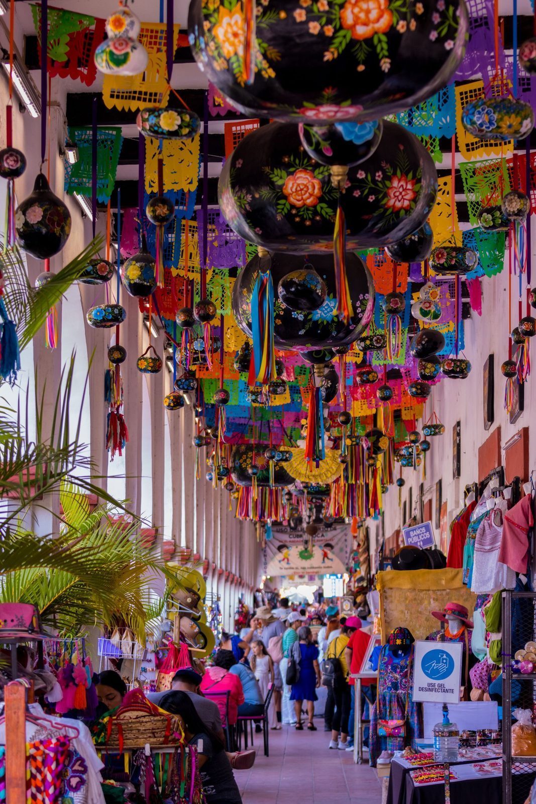 Painted lacquer gourds and papel picado hanging over a market arcade in Chiapa de Corzo
