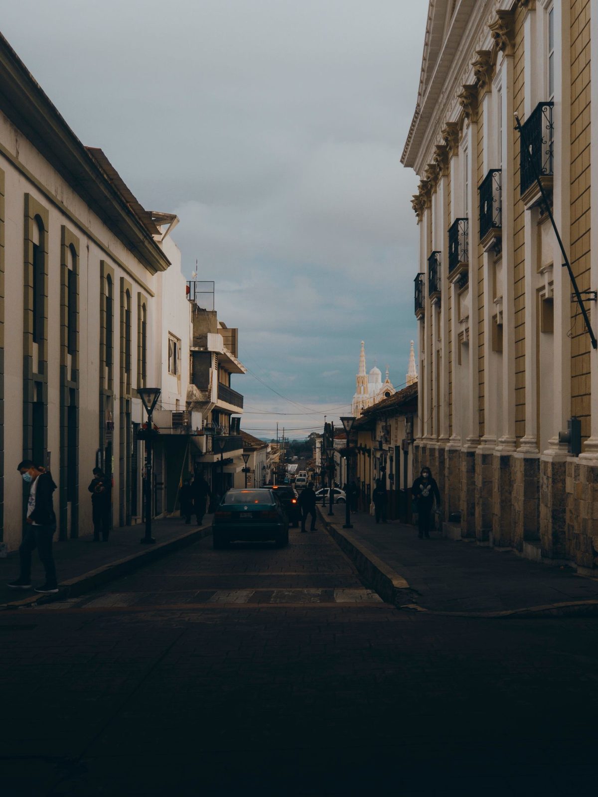 A quiet street in Comitán's Centro Histórico, low colonial facades and parked cars under a highland sky