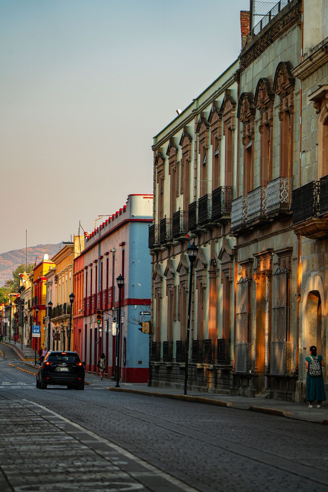 Colonial buildings lit by sunrise on a quiet street in Oaxaca City's centro
