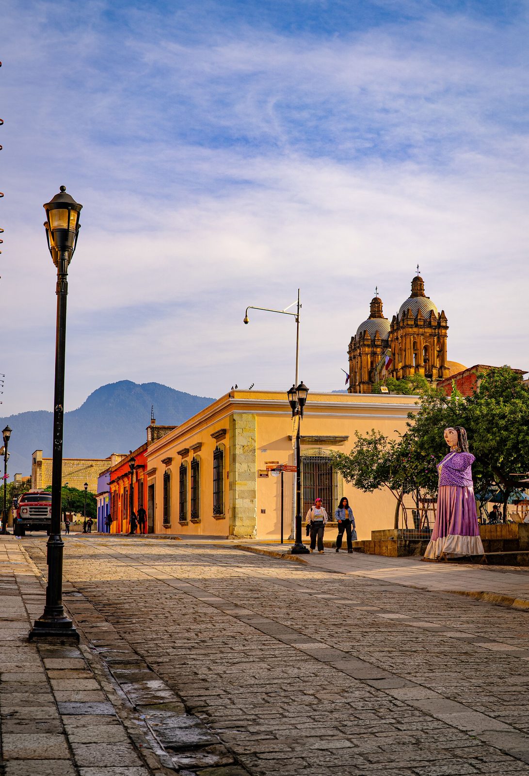 Colorful colonial street in downtown Oaxaca City with Santo Domingo church towers in the background