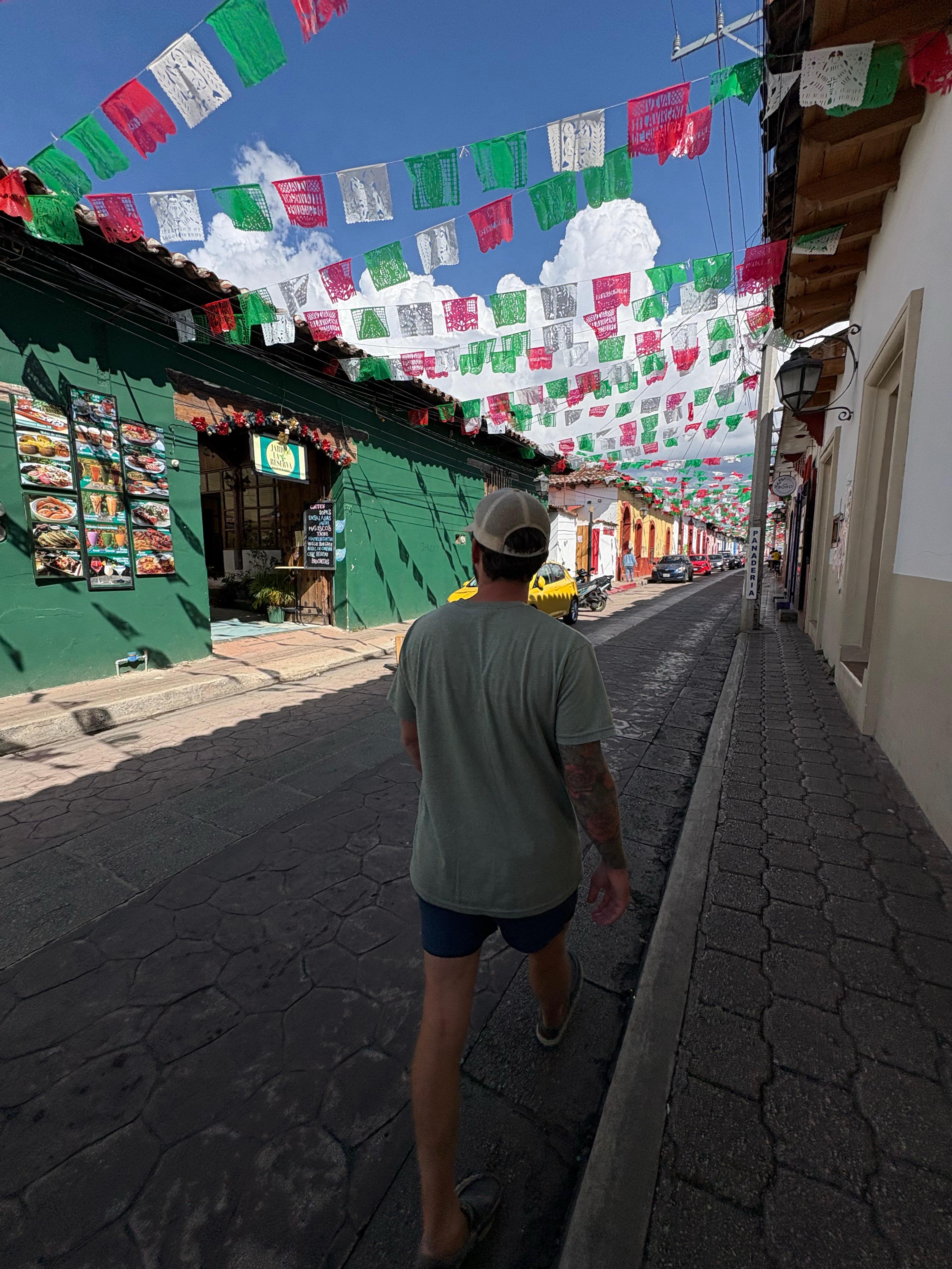 a man walking through the streets of san cristobal de las casas for the free walking tour