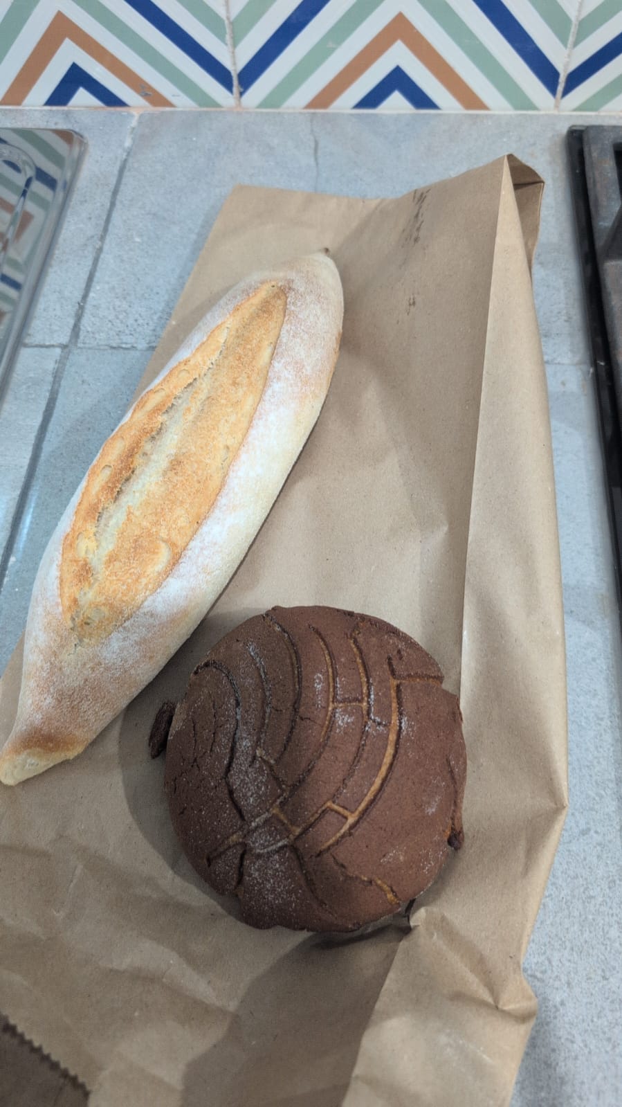 a baguette and cafe flavored concha sitting on a bag from Mitote in Valladolid, Mexico a baguette and cafe flavored concha sitting on a bag from Mitote in Valladolid, Mexico