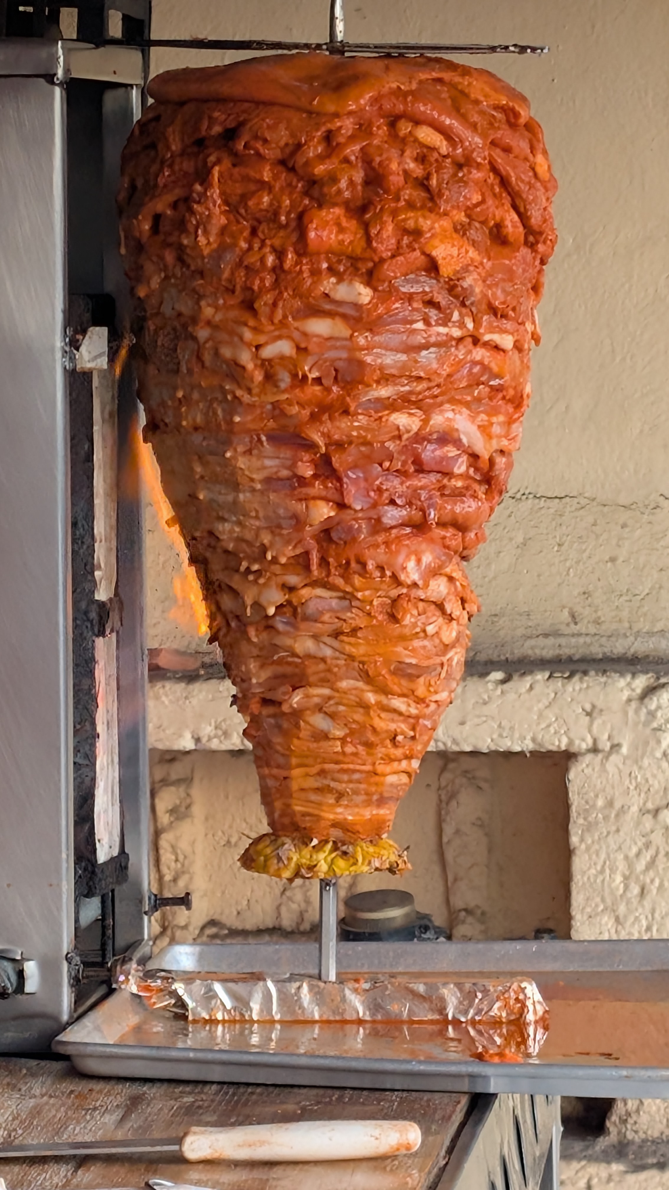 a big chunk of al pastor cooking in front of a restaurant in valladolid mexico a big chunk of al pastor cooking in front of a restaurant in valladolid mexico