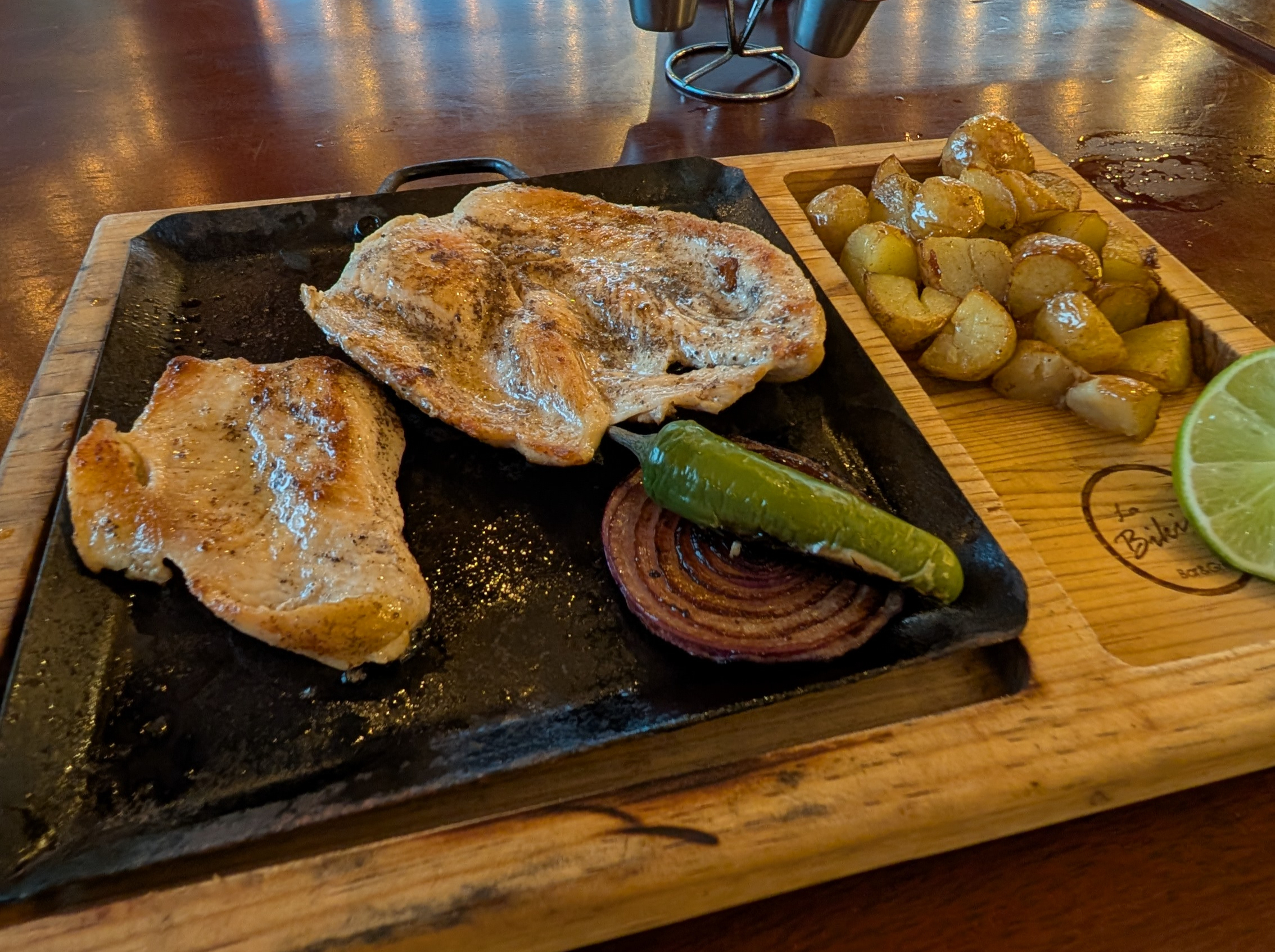 a sizzling plate of chicken and potatoes at a restaurant in Bacalar Mexico