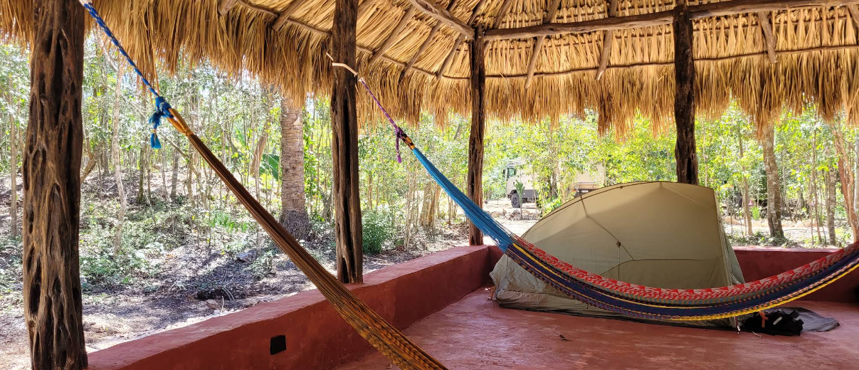 tent under a palapa with some hammocks at Xnuuk cenote near valladolid mexico