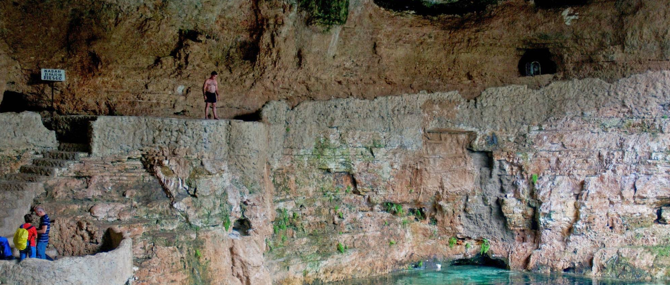 a man about to jump into the water at cenote suytun in valladolid mexico
