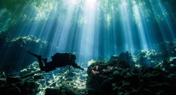 diver in a cenote in tulum mexico