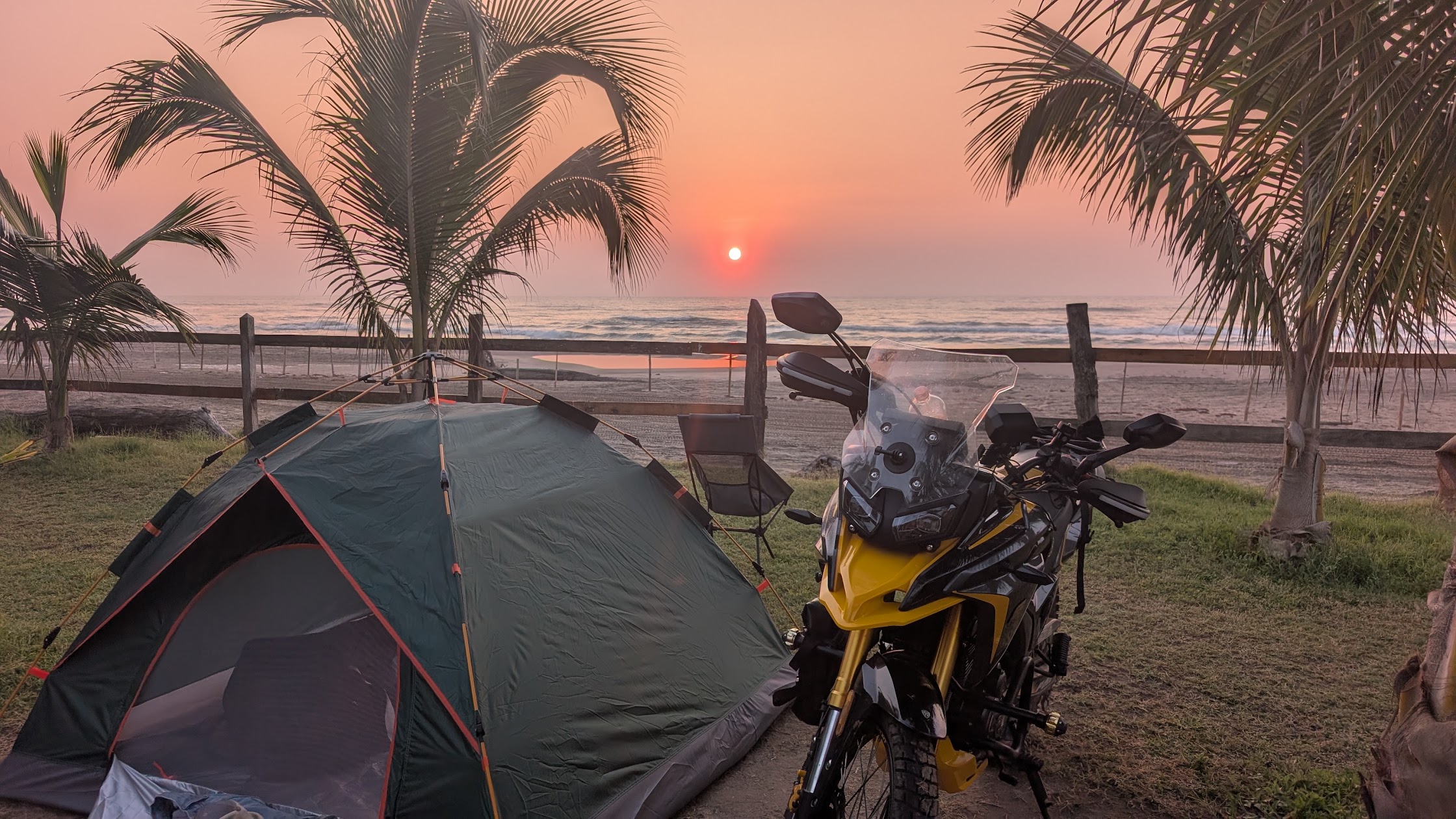 Motorcycle camping setup on a dark sand beach in Chiapas Mexico