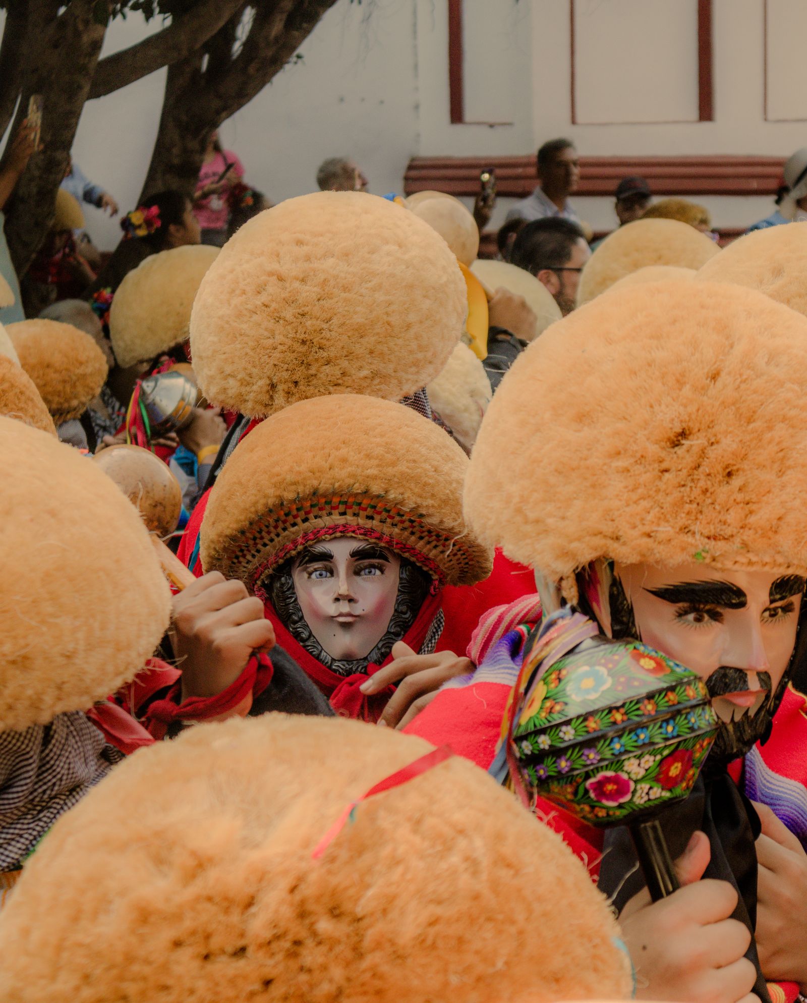 Parachicos in carved wooden masks and blond ixtle-fibre headdresses filling a street during the January Fiesta Grande in Chiapa de Corzo Parachicos in carved wooden masks and blond ixtle-fibre headdresses filling a street during the January Fiesta Grande in Chiapa de Corzo
