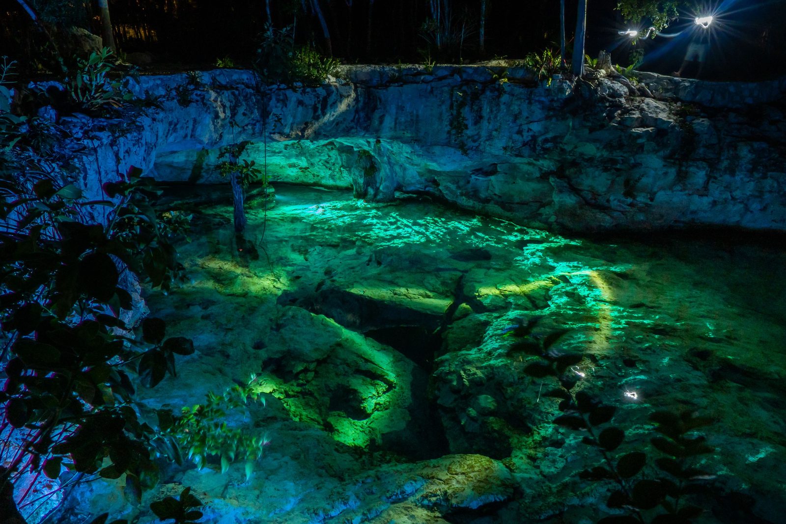 A dry-season cenote in the Valladolid area with clear turquoise water and bright midday sun coming through the opening A dry-season cenote in the Valladolid area with clear turquoise water and bright midday sun coming through the opening