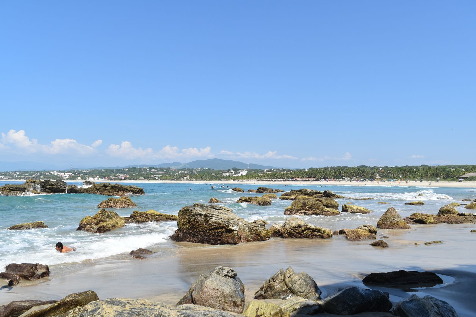 Rocks and surf along the shore in Puerto Escondido under a clear blue sky Rocks and surf along the shore in Puerto Escondido under a clear blue sky