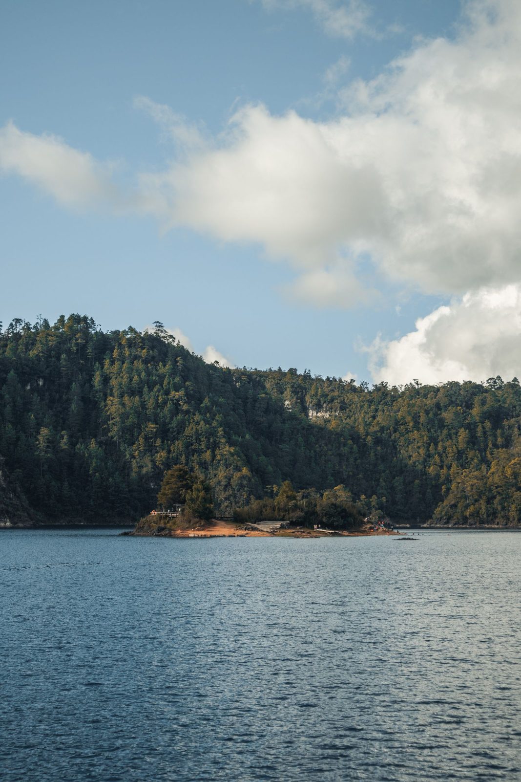 The small wooded island in Laguna Pojoj, Lagos de Montebello National Park, under a big cloudy sky