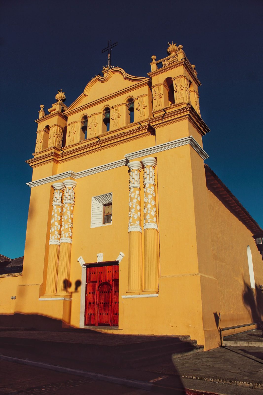 The bright yellow facade and bell tower of the Templo del Calvario rising over the streets of Comitán de Domínguez