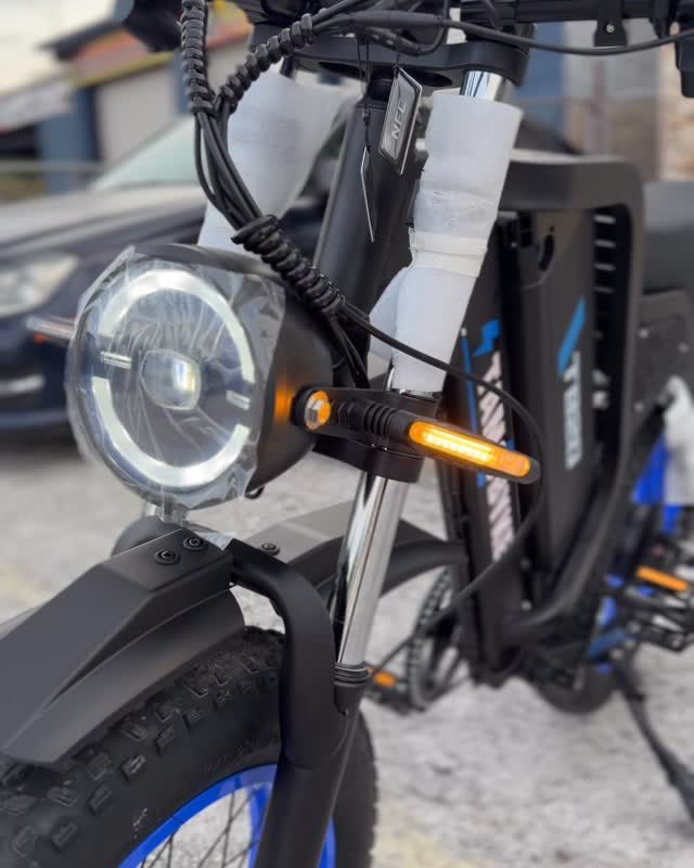 Close on an ebike's round headlight and amber turn signals.