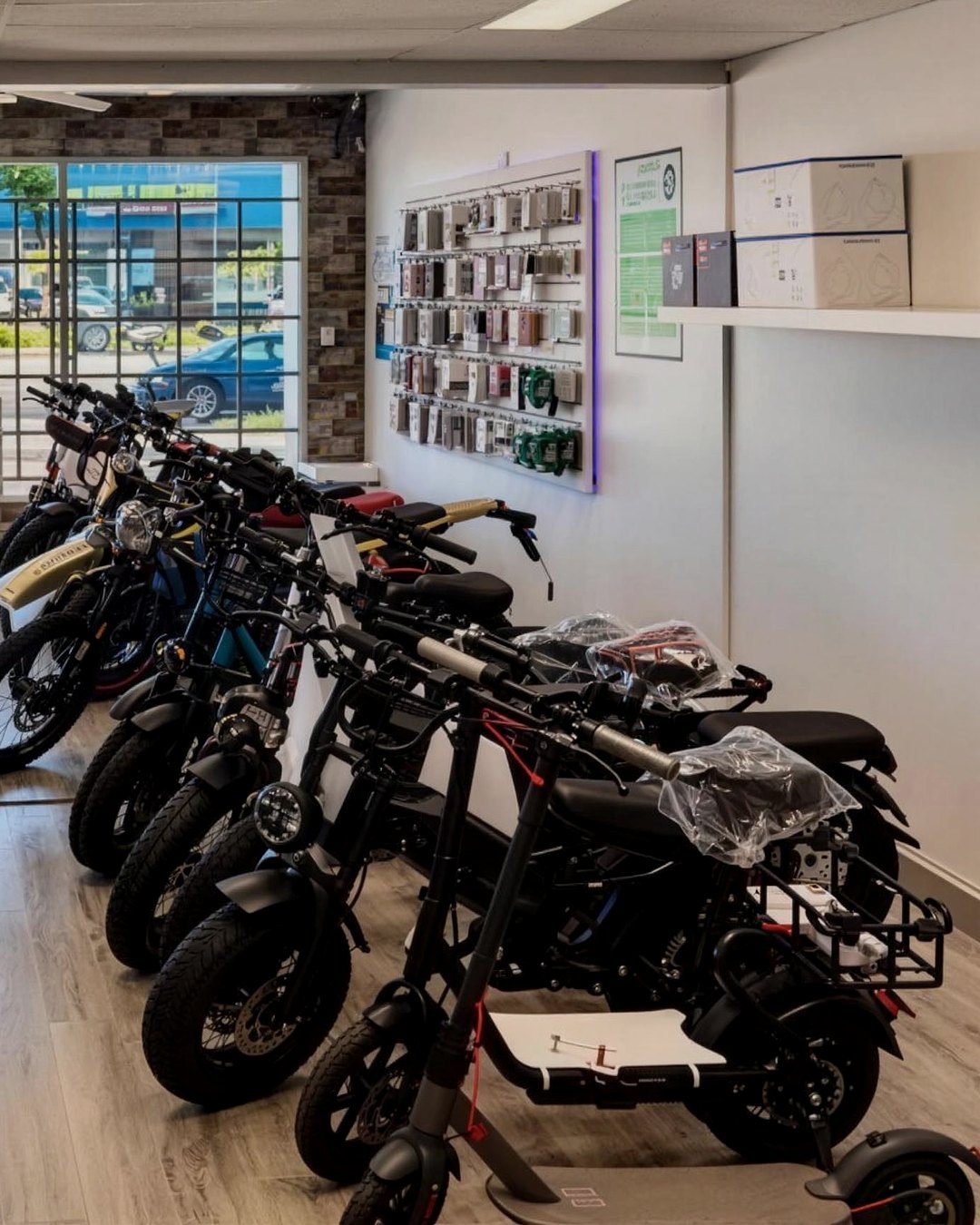 Ebikes and electric scooters lined up inside Smart Phone Fix, the front window behind them.