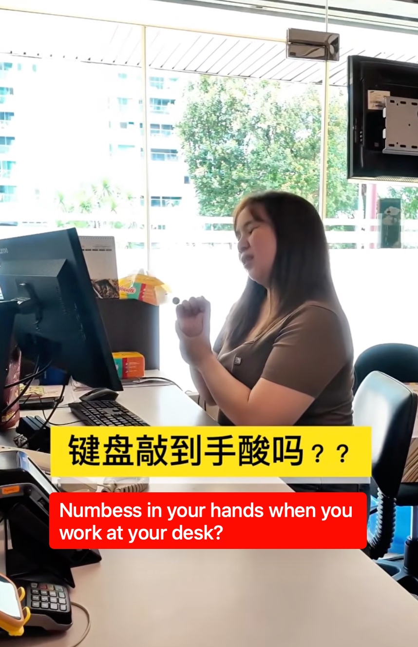 Office worker at a desk with hand discomfort from typing