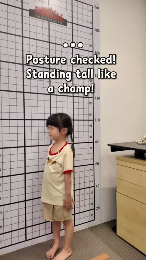 Child standing for posture analysis against the clinic grid