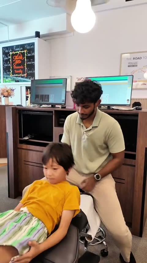 Gentle paediatric chiropractic adjustment on a treatment table at Visit 2