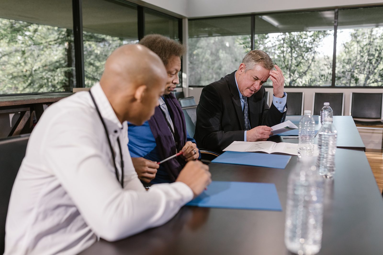 Three reviewers reading documents at a conference table