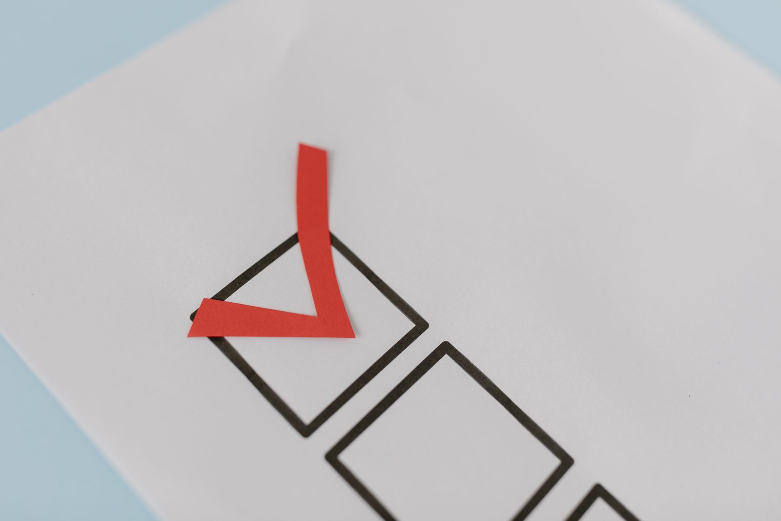 A red check mark in the first box of a checklist A red check mark in the first box of a checklist