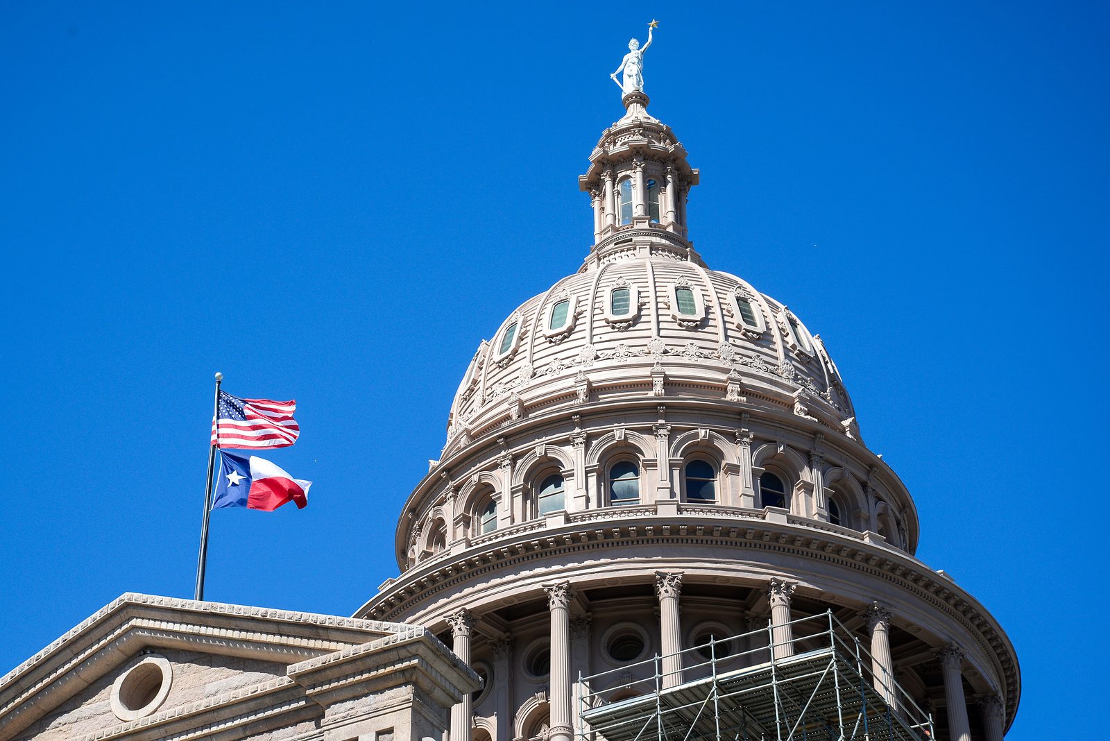 The Texas State Capitol dome with the U.S. and Texas flags