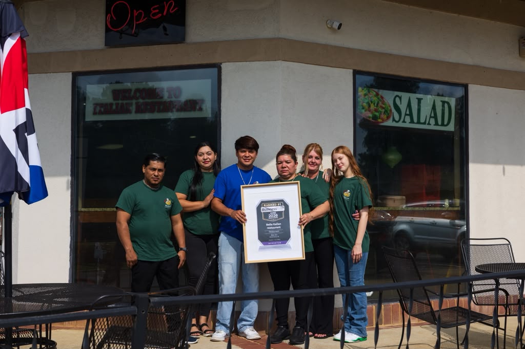 The Ortiz family and Bella Italian Restaurant team holding their Ranked #1 award outside the restaurant